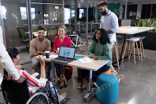 Preview: Happy biracial advisors listening to disabled businesswoman's strategy during meeting in boardroom
