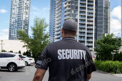 Preview: Security guard in uniform patrolling a residential area.
