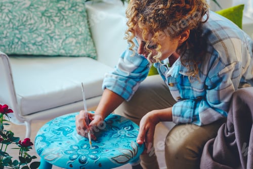 Preview: One woman painting with brush and old footstool. Renovating furnitures in diy alone leisure