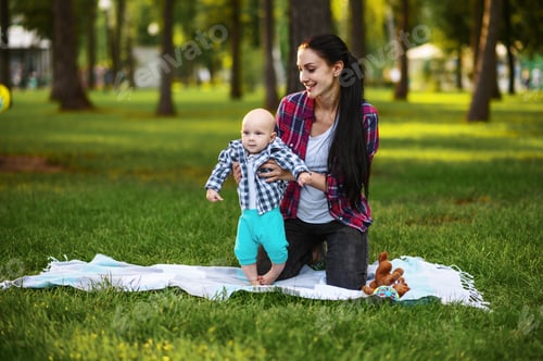 Preview: Mother play with little baby on the grass in park