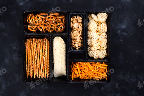 Preview: a variety of snacks on the box for beer on a concrete black table