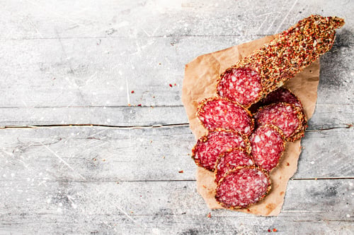 Preview: Pieces of delicious salami sausage on the table.