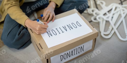 Preview: Close up of a person labeling a donation box at home. Concept of charity, giving, and community