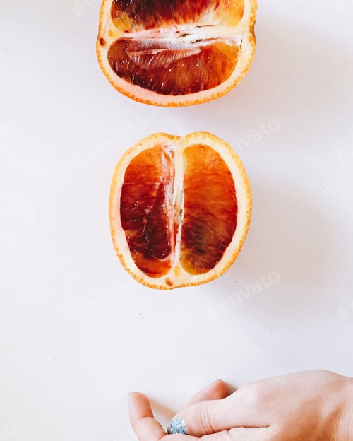 Preview: Blood Oranges Sliced in Half with Hand