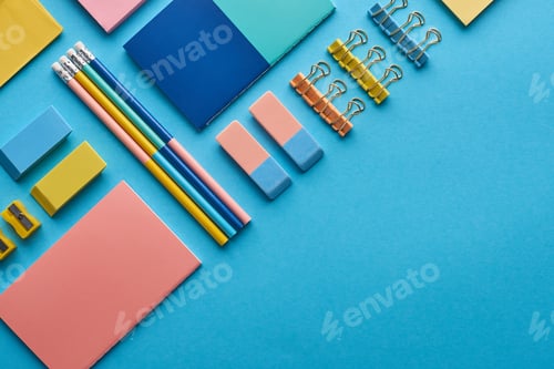 Preview: top view of notebooks and colorful stationery isolated on blue with copy space