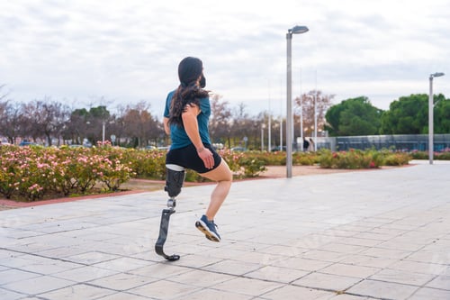 Preview: Jogger with prosthetic leg running along an urban park