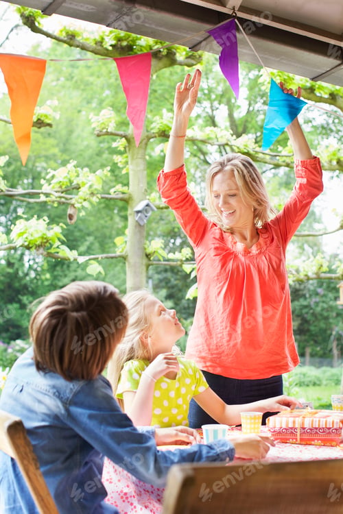 Preview: Mother chatting with children and putting up bunting
