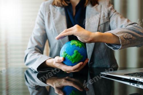 Preview: A professional holds a model Earth, symbolizing global awareness, eco responsibility