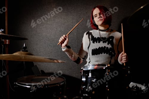 Preview: Teenage Girl Focused on Drumming while Performing Punk Rock Music Indoors