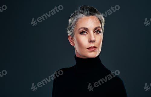 Preview: Studio portrait of a beautiful mature woman posing against a dark background