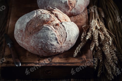 Preview: Homemade and tasty loaf of bread on dark table.