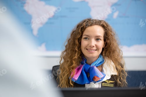Preview: Smiling Caucasian female officer at airport check in counter service.