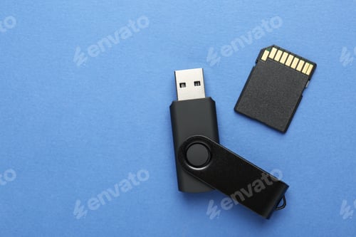 Preview: Flash drive and SD memory card on blue background, flat lay. Space for text
