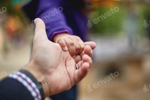 Preview: Father and daughter holding hands, close-up