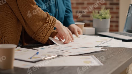 Preview: Close up of business people looking at papers with rate charts