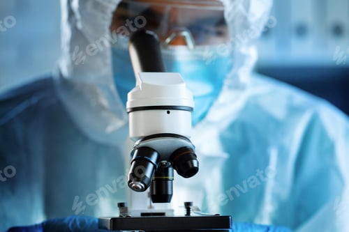 Preview: Medical worker in protective gown looking in microscope