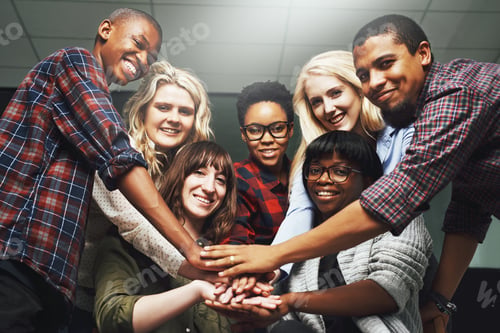 Smiling Colleagues Put Hands Together in Workplace