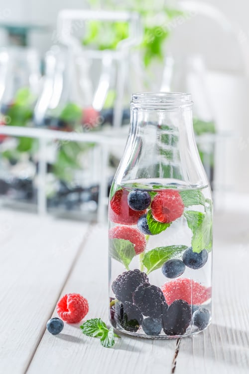 Vista previa: Sparkling water in bottle with raspberries, blueberries and blackberries