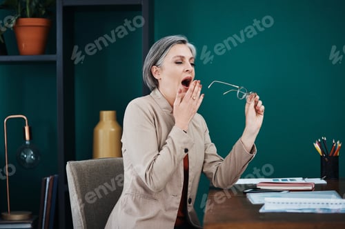 Preview: Cropped shot of an attractive mature businesswoman sitting alone and yawning in her home office