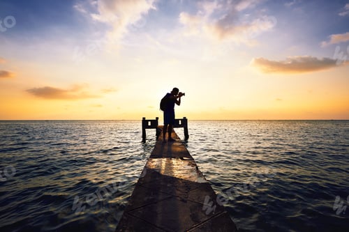 Photographer Silhouette on Pier at Golden Hour
