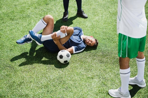 Preview: injured soccer player lying on football field during match