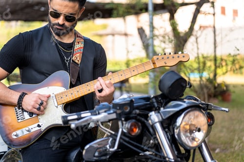 Preview: Man Plays Electric Guitar Beside Motorcycle Outdoors