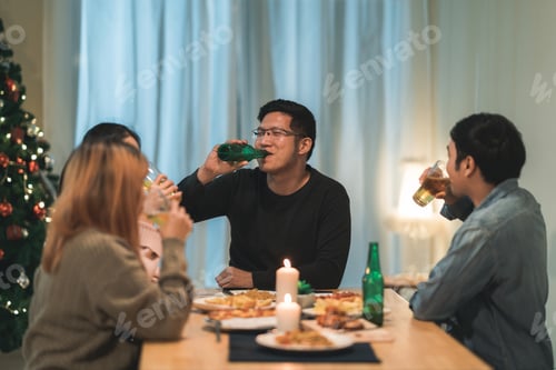 Preview: Merry Christmas and Happy New Year! Young friends group having dinner at home.