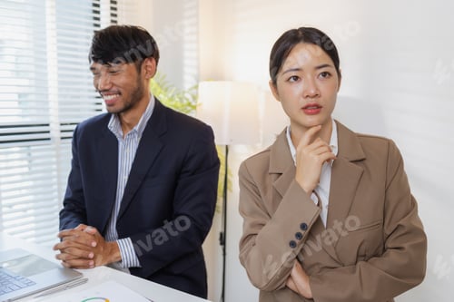 Preview: A group of business professionals engaged in a serious office discussion