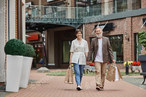 Preview: happy elderly couple having shopping, senior man and woman holding hands and walking on street