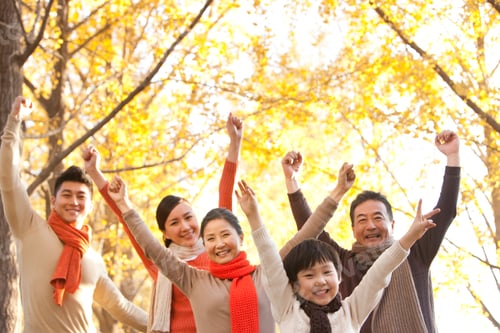 Preview: Family with arms raised surrounded by Autumn trees