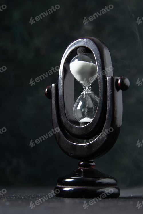 Preview: front view of black hourglass on dark desk funeral evil israel war death time