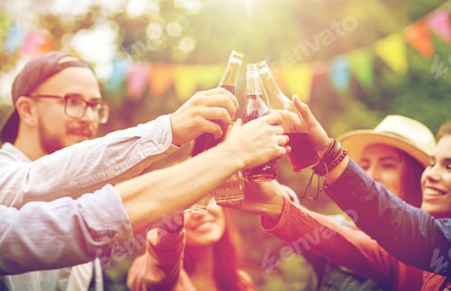 Preview: happy friends clinking glasses at summer garden