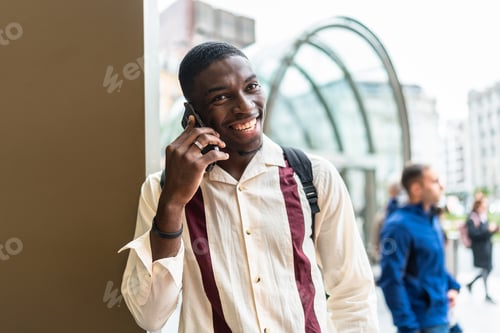 Preview: Happy young man calling with phone in city