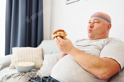 Preview: Funny overweight man in casual clothes is indoors at home