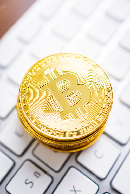 Preview: Cryptocurrency. Bitcoin virtual money. Gold coins laying on computer keyboard.
