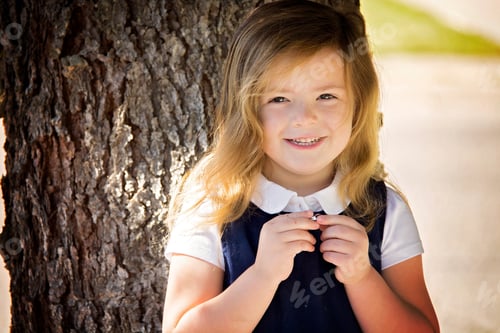Preview: A little girl holds tight to a special locket she received for her first day of school.