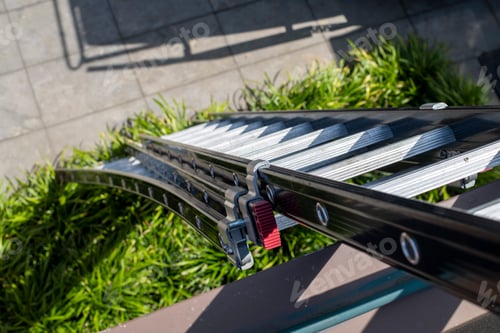 Preview: An empty outdoor bench basking in the sunlight with shadows playing across its metal frame