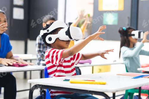 Preview: In school, diverse students wearing virtual reality headsets are reaching out in the classroom
