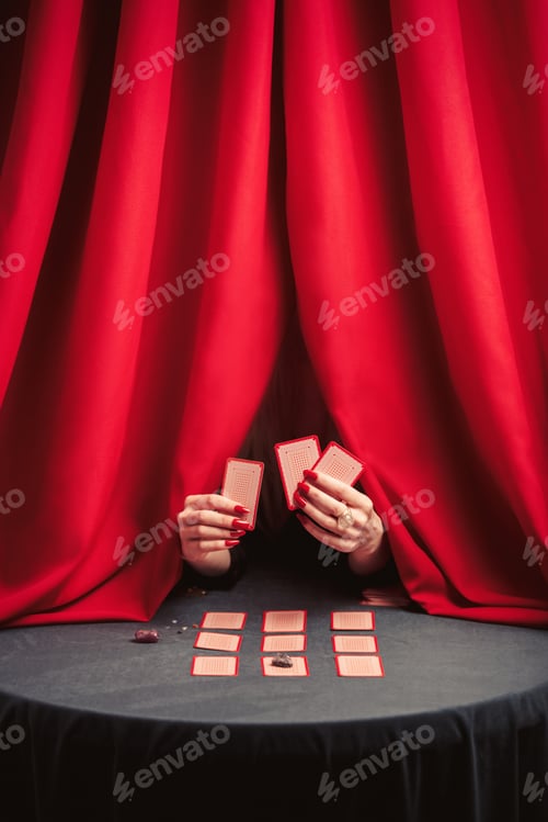 Preview: fortune-teller is guessing on the cards huddling behind red curtains.