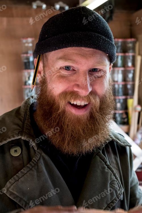 Preview: Portrait of smiling bearded man with light brown hair, wearing black beanie.