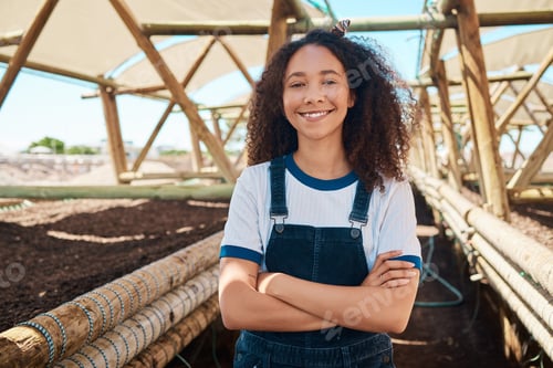 Preview: Portrait of a young woman standing with her arms crossed while working on a farm