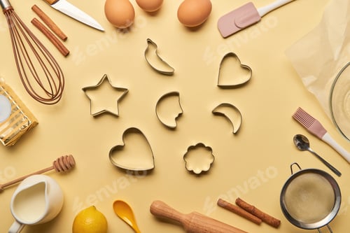 Preview: top view of bakery ingredients and cooking utensils around dough molds