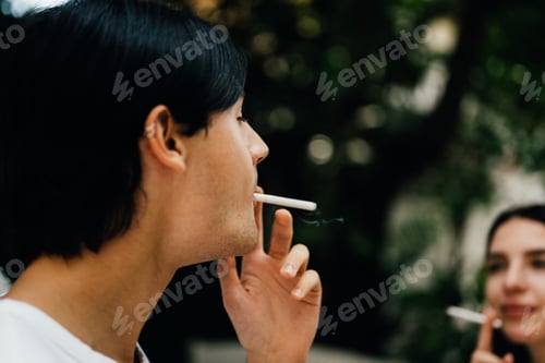 Preview: Young couple of man and woman smoking cigarette together