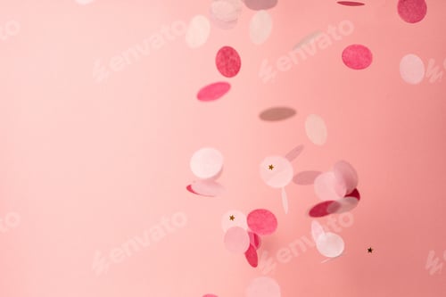 Preview: Pink confetti on pink background. Copyspace for text. Bright and festive holiday background.