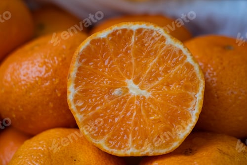 Preview: A bunch of orange fruits with an orange half peeled. Orange fruit full of vitamin C.