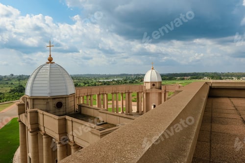 Preview: Basilica of Our Lady of Peace overlooks lush Yamoussoukro, Ivory Coast, under clouds