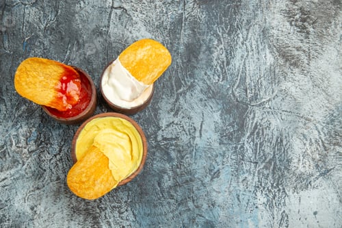 Preview: Horizontal view of homemade crispy potato chips ketchup mayonnaise sauce on gray table