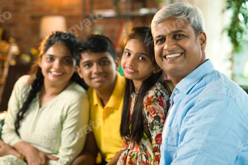 Preview: Cheerful Indian Asian family poses for a close-up photo while sitting on the sofa