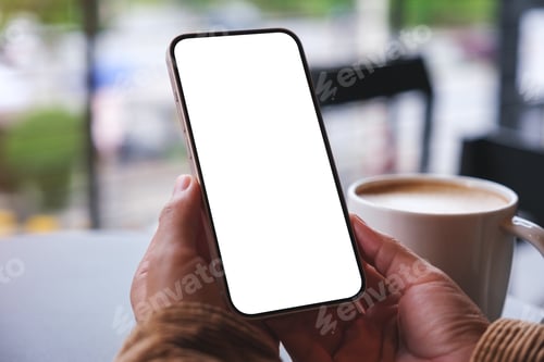 Preview: Mockup image of a woman holding mobile phone with blank desktop screen with coffee cup on the table