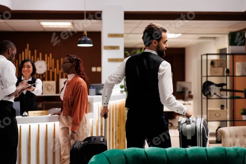 Preview: Hotel bellboy helping guests with bags